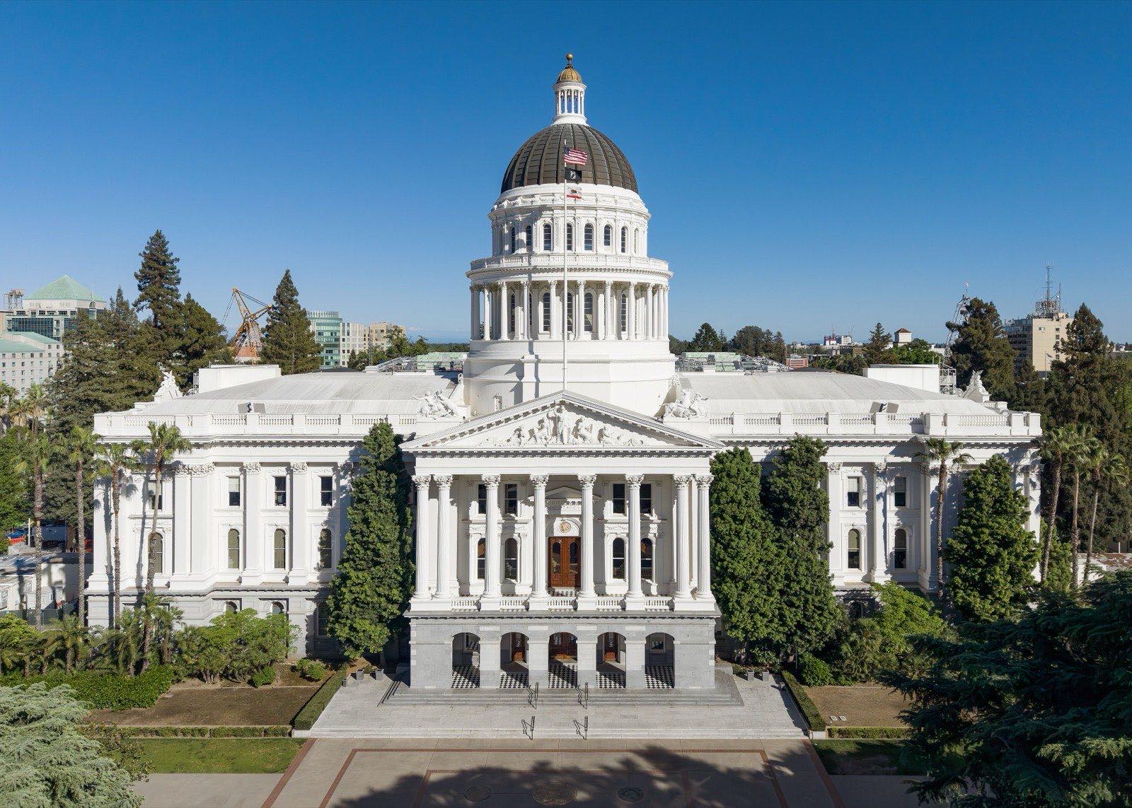 The white neoclassical California State Capitol in Sacramento under a clear blue sky